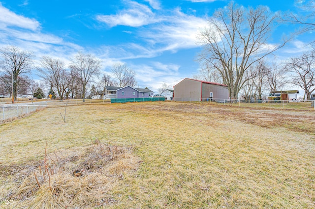 view of yard with fence and an outbuilding