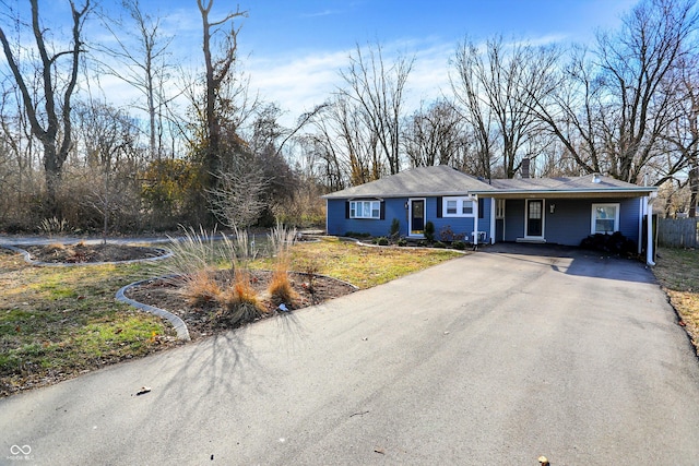 ranch-style house featuring driveway and a chimney