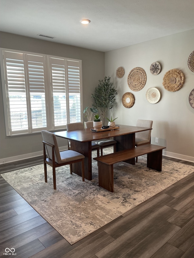 dining space with visible vents, baseboards, and wood finished floors