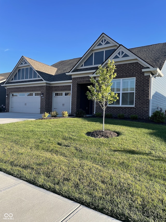 view of front of house with a garage, brick siding, driveway, roof with shingles, and a front lawn