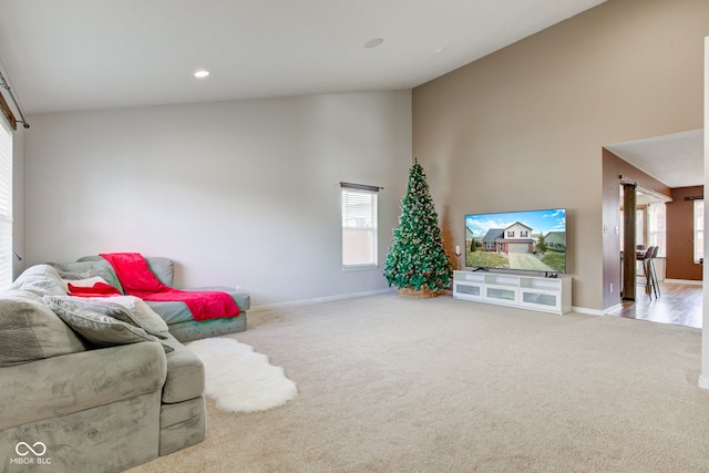 carpeted living room with high vaulted ceiling, baseboards, and recessed lighting