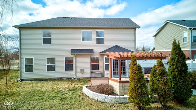 rear view of property featuring a patio area, a shingled roof, a pergola, and a yard