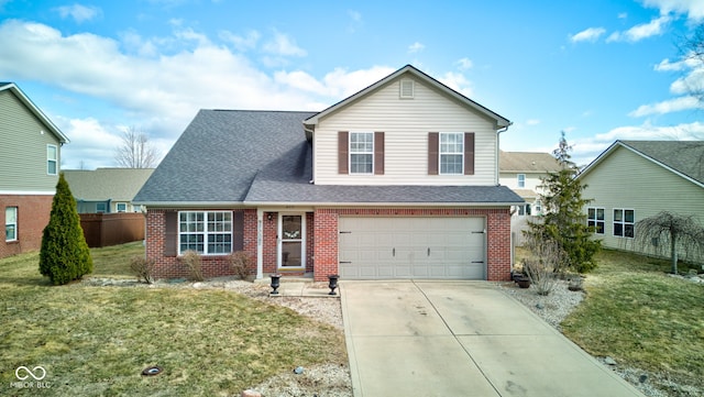 traditional-style home with an attached garage, brick siding, fence, driveway, and a front yard