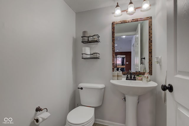 bathroom featuring toilet and baseboards