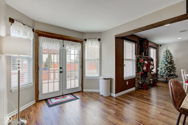 doorway to outside featuring french doors, baseboards, and wood finished floors