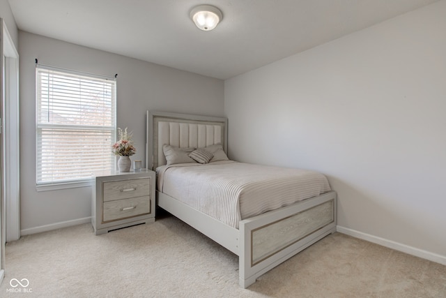 bedroom featuring baseboards and light colored carpet