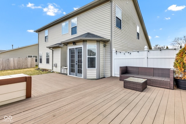 deck featuring french doors, fence, and an outdoor living space