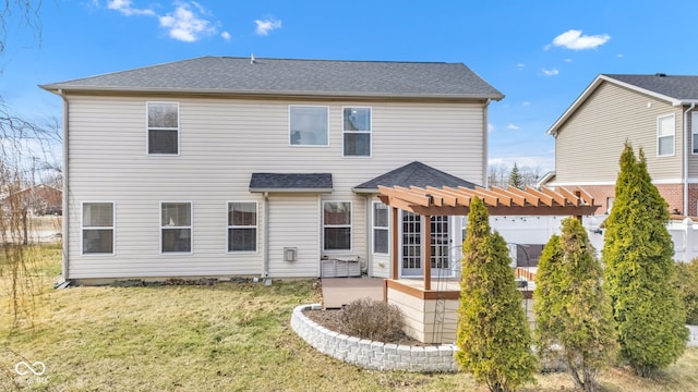 rear view of house featuring a patio area, a shingled roof, a pergola, and a yard