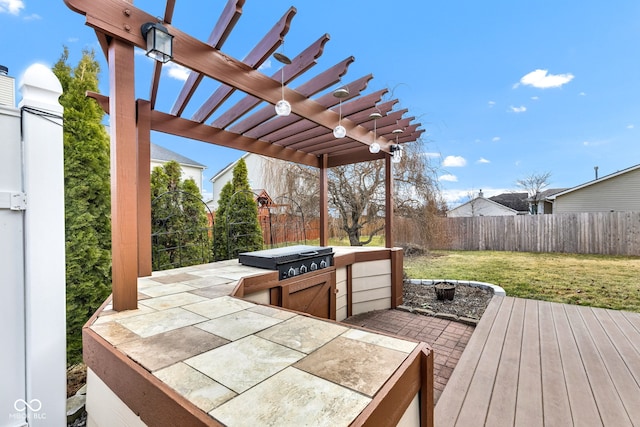 wooden terrace featuring a fenced backyard, a yard, an outdoor kitchen, and a pergola