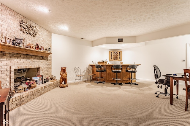 recreation room featuring indoor wet bar, carpet, baseboards, and a textured ceiling