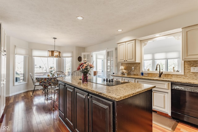 kitchen with tasteful backsplash, dark wood-style flooring, black appliances, and a sink