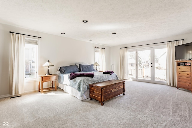 carpeted bedroom featuring visible vents, a textured ceiling, and access to outside