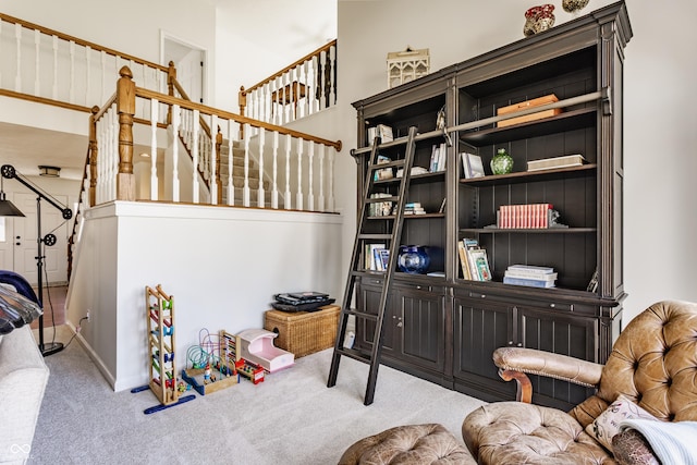 living area featuring stairway and carpet floors