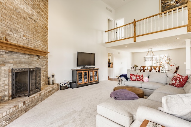 living area with a high ceiling, a brick fireplace, carpet, and visible vents