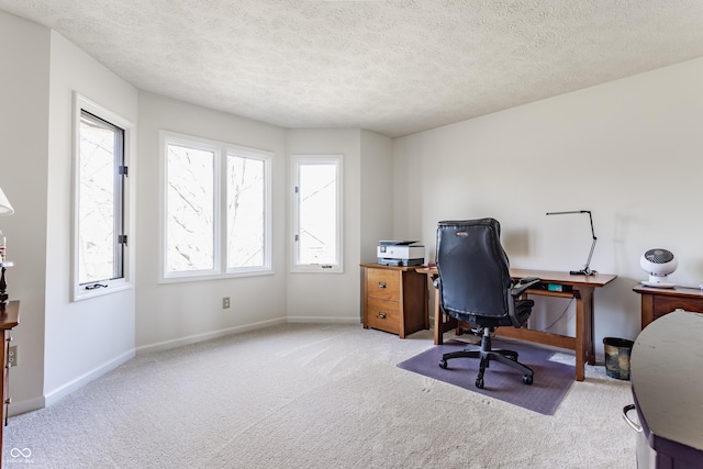 carpeted office space with baseboards and a textured ceiling