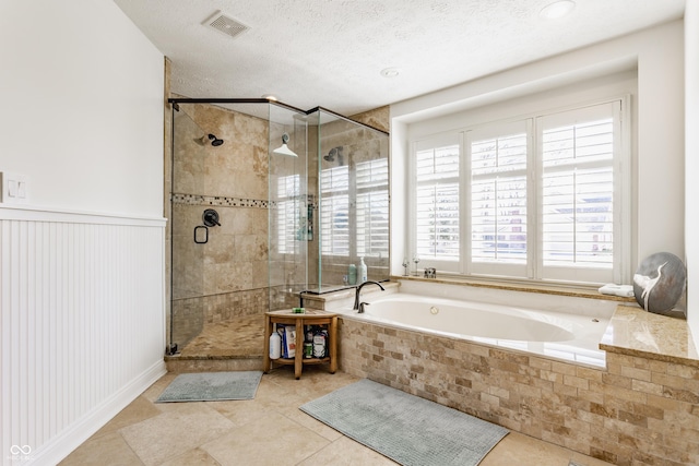 full bath featuring a stall shower, visible vents, a textured ceiling, and a bath