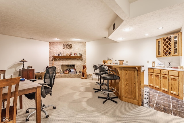 office featuring indoor bar, carpet floors, recessed lighting, a fireplace, and a textured ceiling