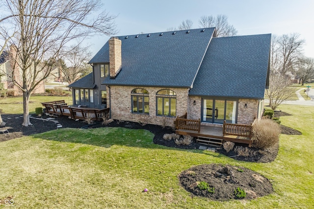 back of house featuring a lawn, a chimney, and a wooden deck