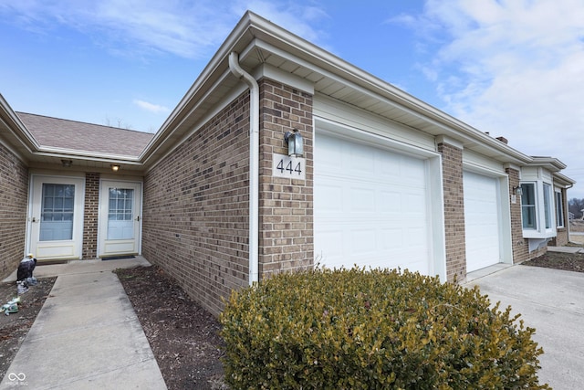 view of home's exterior with brick siding, driveway, and an attached garage