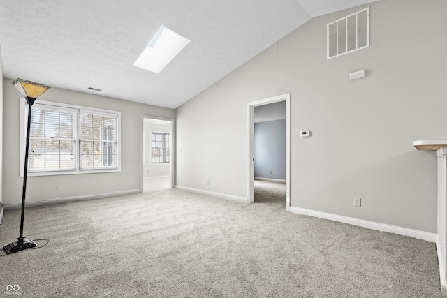 interior space featuring a skylight, baseboards, visible vents, and carpet flooring