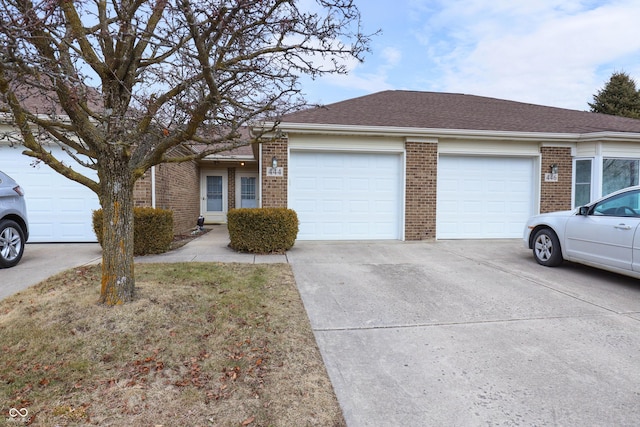 ranch-style house with driveway, brick siding, roof with shingles, and an attached garage