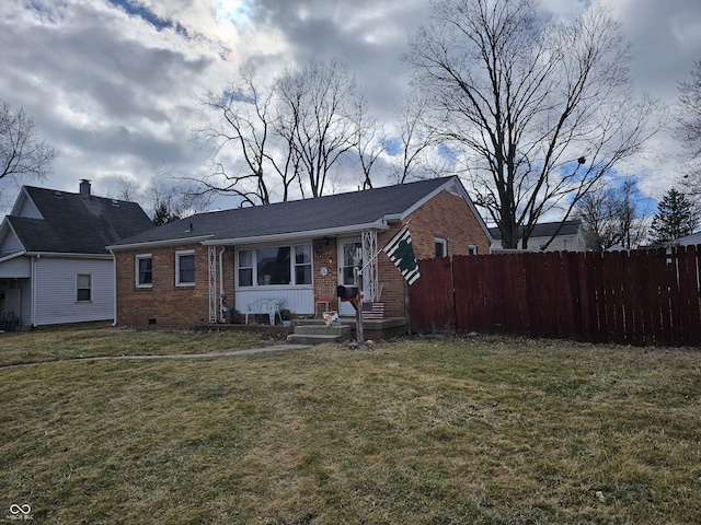 view of front of house with crawl space, brick siding, fence, and a front lawn