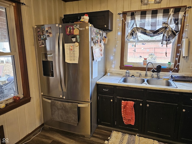 kitchen with dark wood-style floors, stainless steel refrigerator with ice dispenser, a sink, and dark cabinets