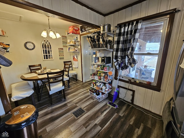 dining room featuring dark wood-style flooring, visible vents, and a notable chandelier