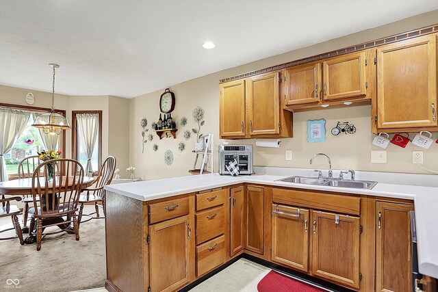 211 Deborah Ln, Whiteland, IN 46184 - kitchen with a sink, a peninsula, brown cabinets, light countertops, and recessed lighting