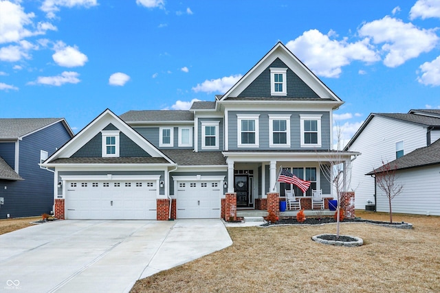 craftsman-style home featuring an attached garage, covered porch, concrete driveway, and brick siding