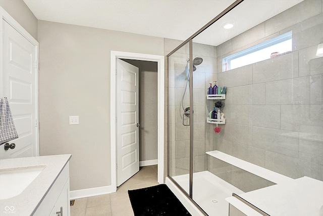 bathroom featuring tile patterned floors, a shower stall, baseboards, and vanity