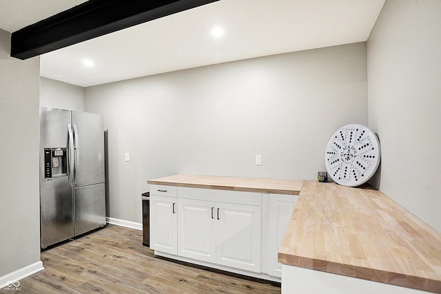 kitchen featuring light wood-style flooring, a peninsula, butcher block countertops, white cabinetry, and stainless steel refrigerator with ice dispenser