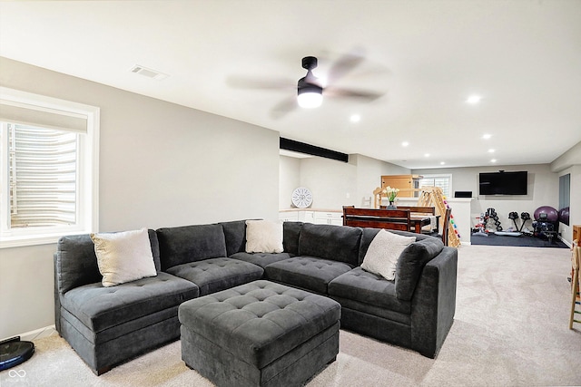 living area with recessed lighting, light carpet, visible vents, and baseboards