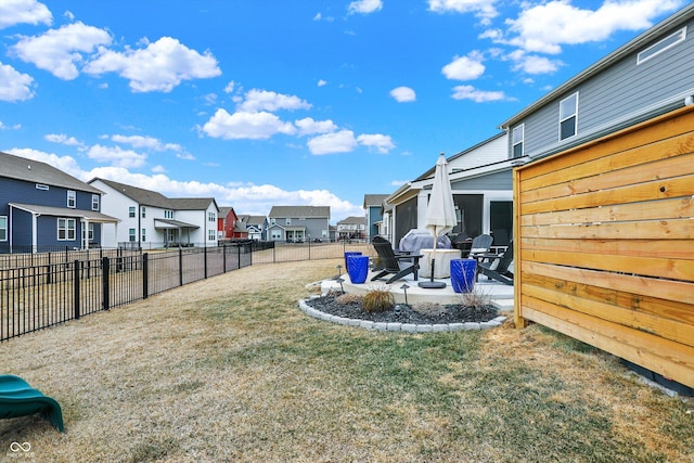 view of yard featuring a patio area, a fenced backyard, and a residential view