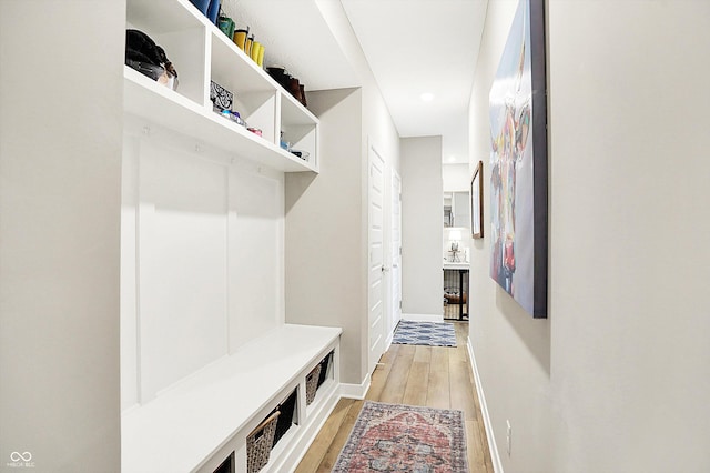 mudroom featuring light wood finished floors and baseboards