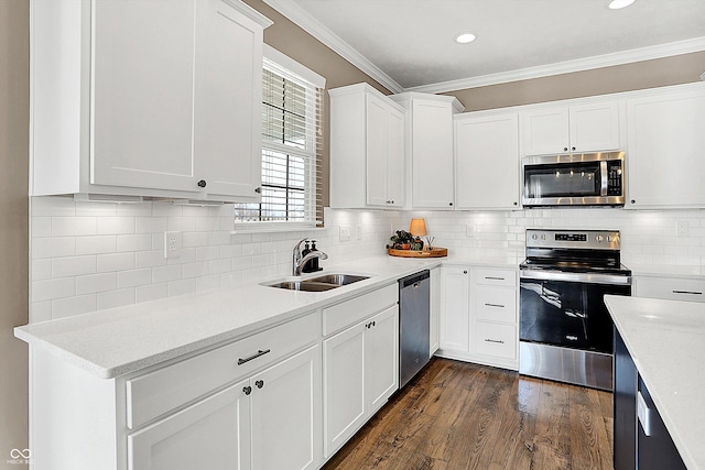 kitchen with stainless steel appliances, dark wood-type flooring, ornamental molding, white cabinets, and a sink