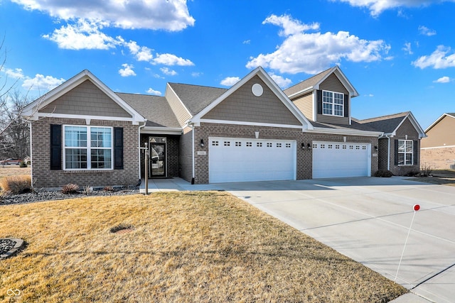 view of front of house with an attached garage, a front yard, concrete driveway, and brick siding