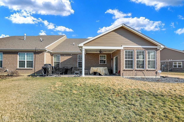 back of house with a shingled roof, ceiling fan, a yard, a patio area, and brick siding