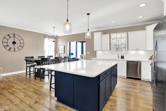 kitchen featuring a center island, stainless steel appliances, backsplash, light wood-style floors, and a kitchen bar