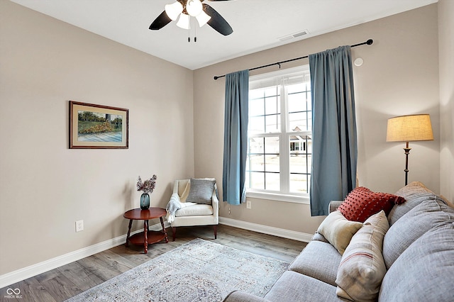 sitting room with visible vents, ceiling fan, baseboards, and wood finished floors