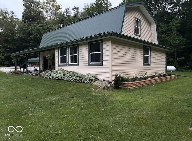 view of home's exterior with metal roof, a yard, and a gambrel roof