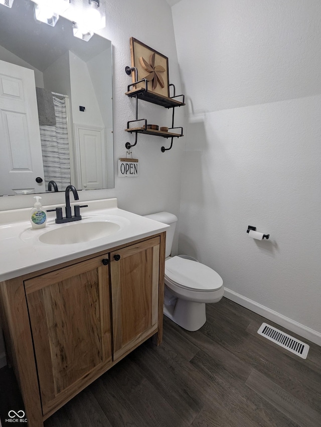 full bath with toilet, wood finished floors, vanity, visible vents, and baseboards