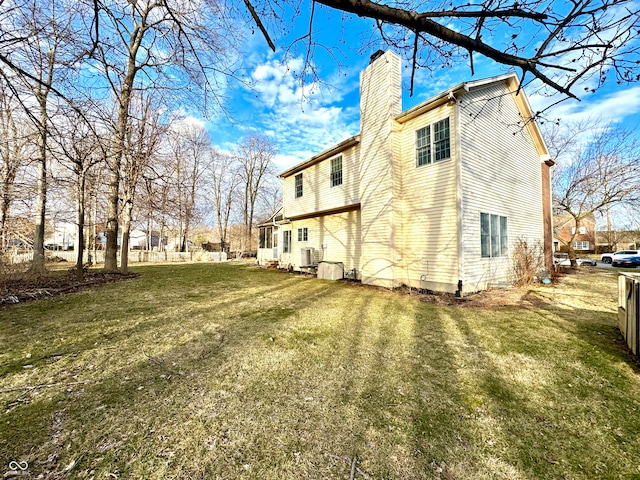 rear view of house with a yard and a chimney