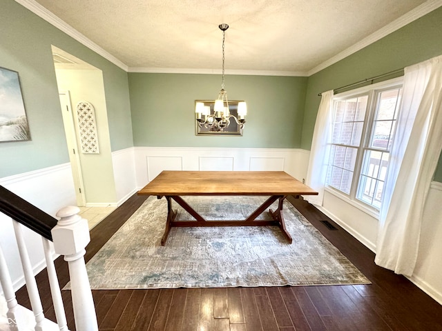 unfurnished dining area featuring dark wood-style floors, a wainscoted wall, visible vents, and an inviting chandelier