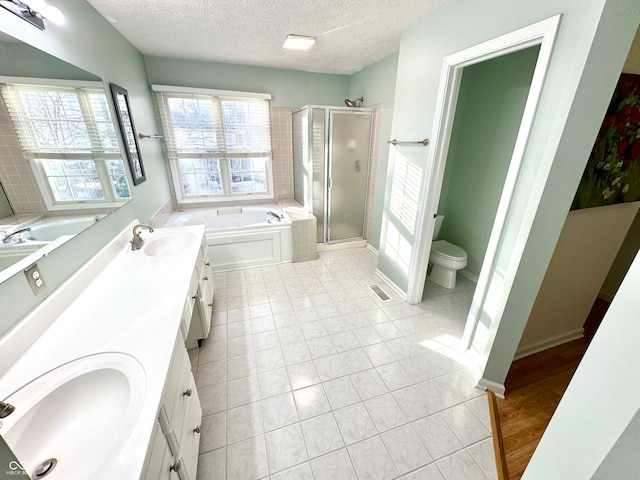 bathroom featuring double vanity, a stall shower, a garden tub, and a sink