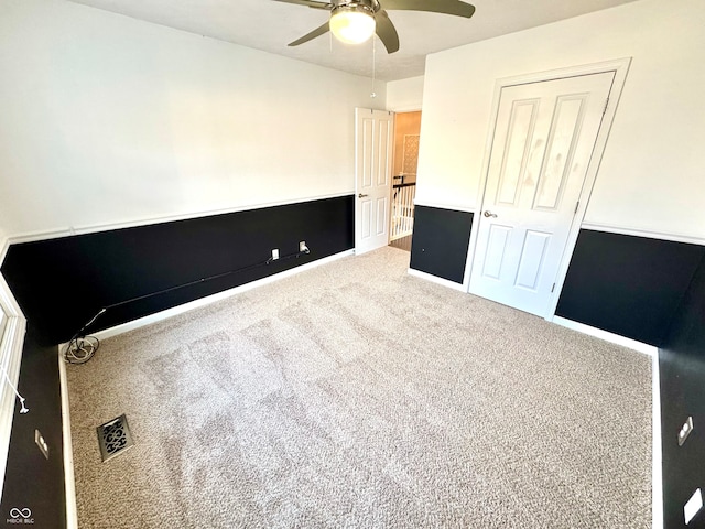 unfurnished bedroom with baseboards, carpet, visible vents, and a ceiling fan