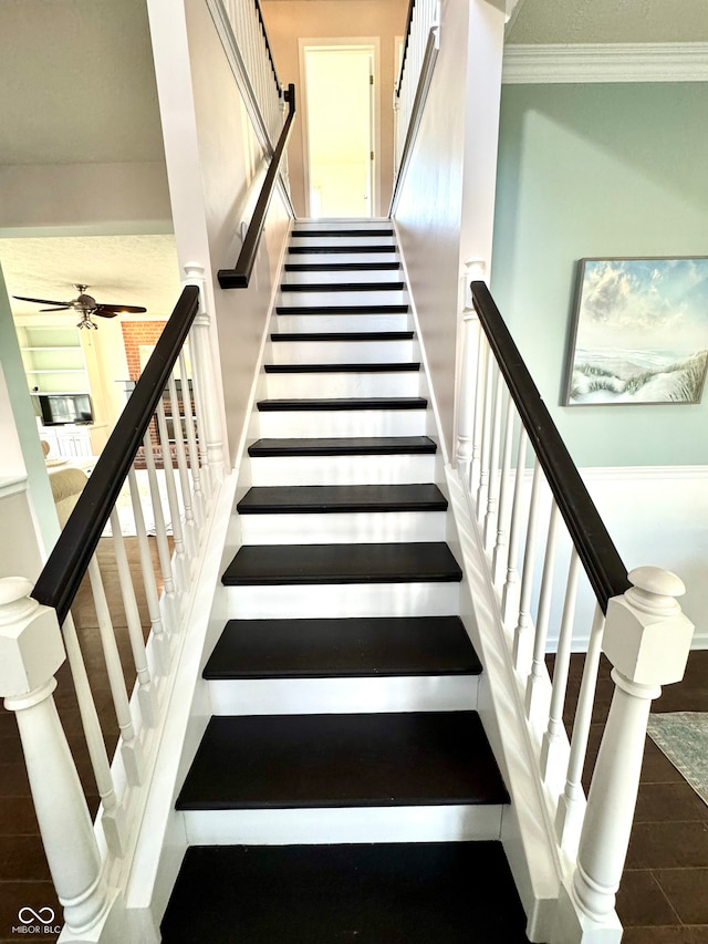 stairway with wood finished floors, crown molding, and ceiling fan