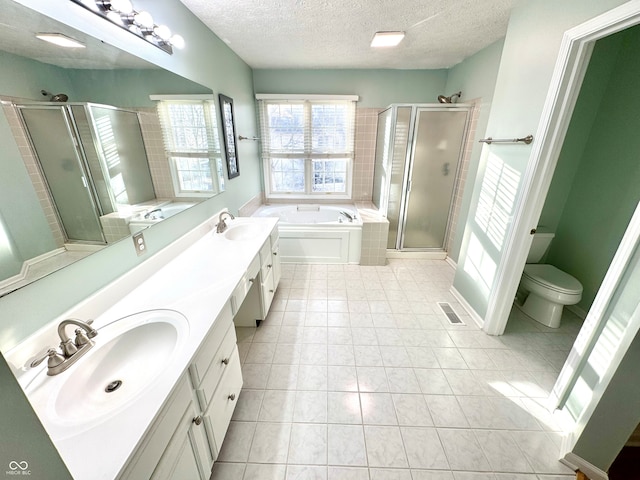 full bathroom with visible vents, a sink, a shower stall, and a garden tub