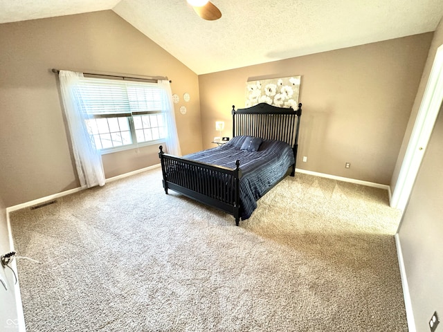 bedroom featuring vaulted ceiling, a textured ceiling, carpet flooring, and visible vents