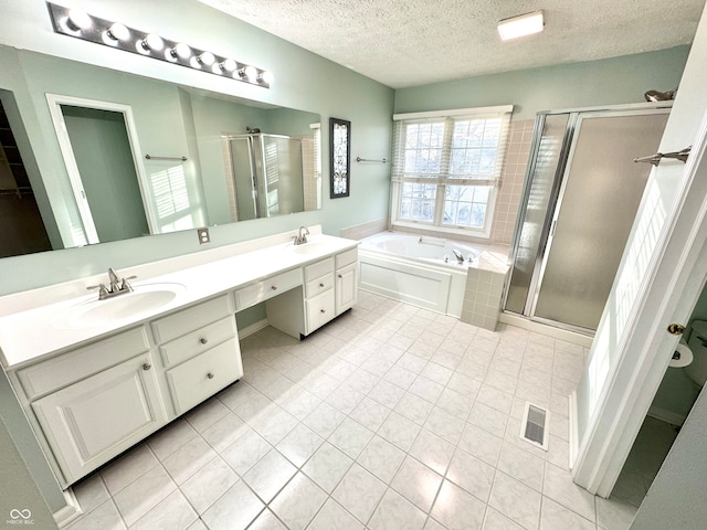 bathroom with a garden tub, a sink, visible vents, double vanity, and a stall shower